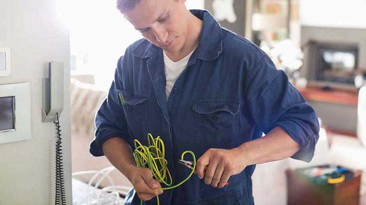 Professional electrician inspecting wires.