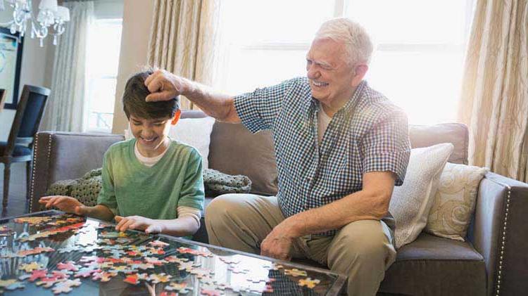 Grandfather and child putting a puzzle together.